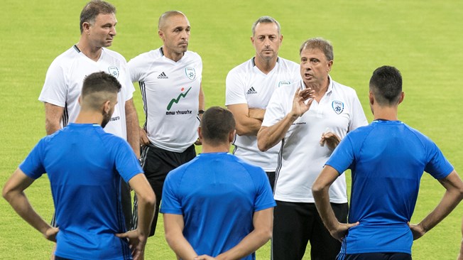 Israeli national football team's head coach, Elisha Levy (3rdR) talks to his players